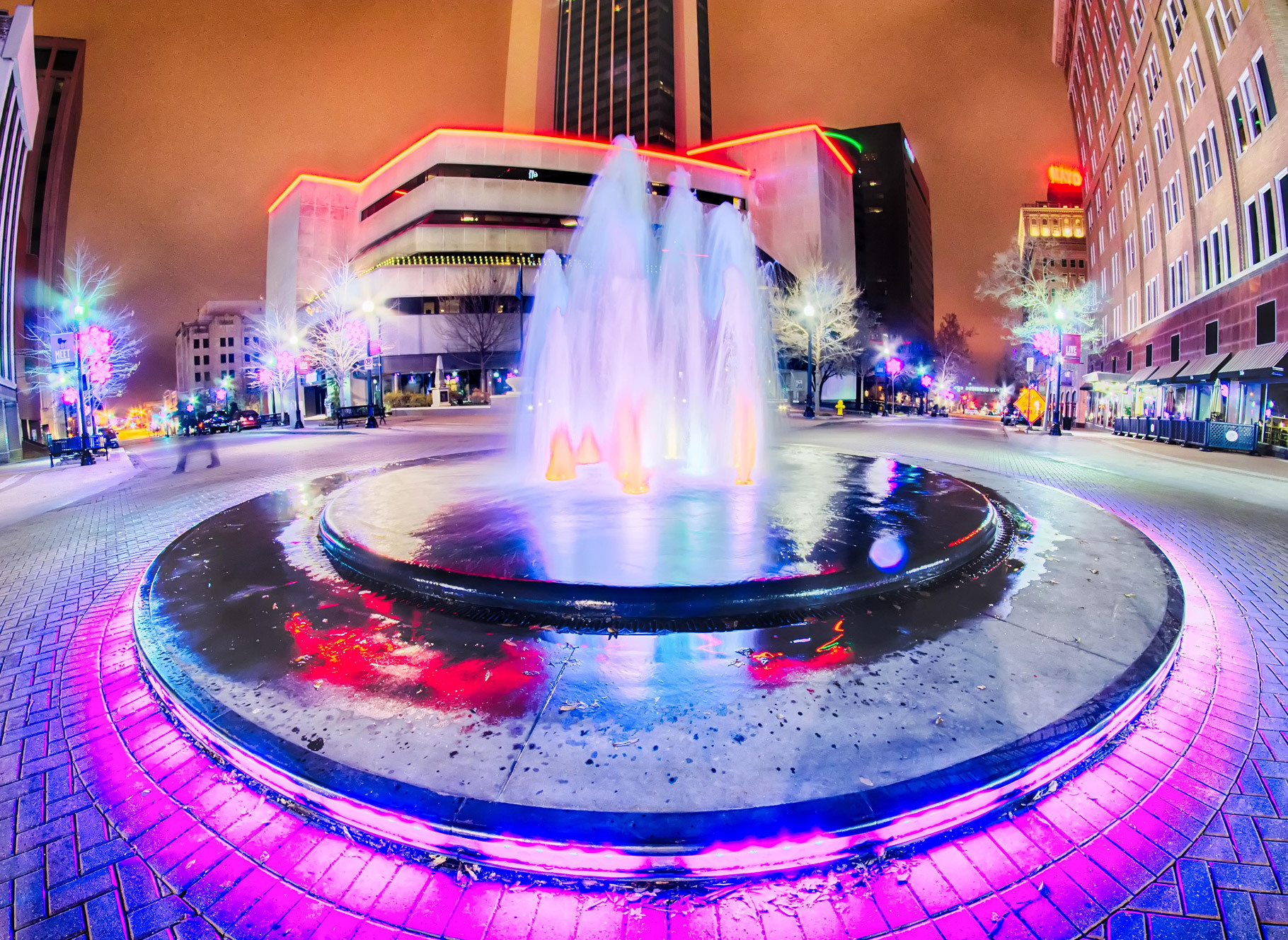 A colorful water fountain at the center of an intersection in downtown Tulsa
